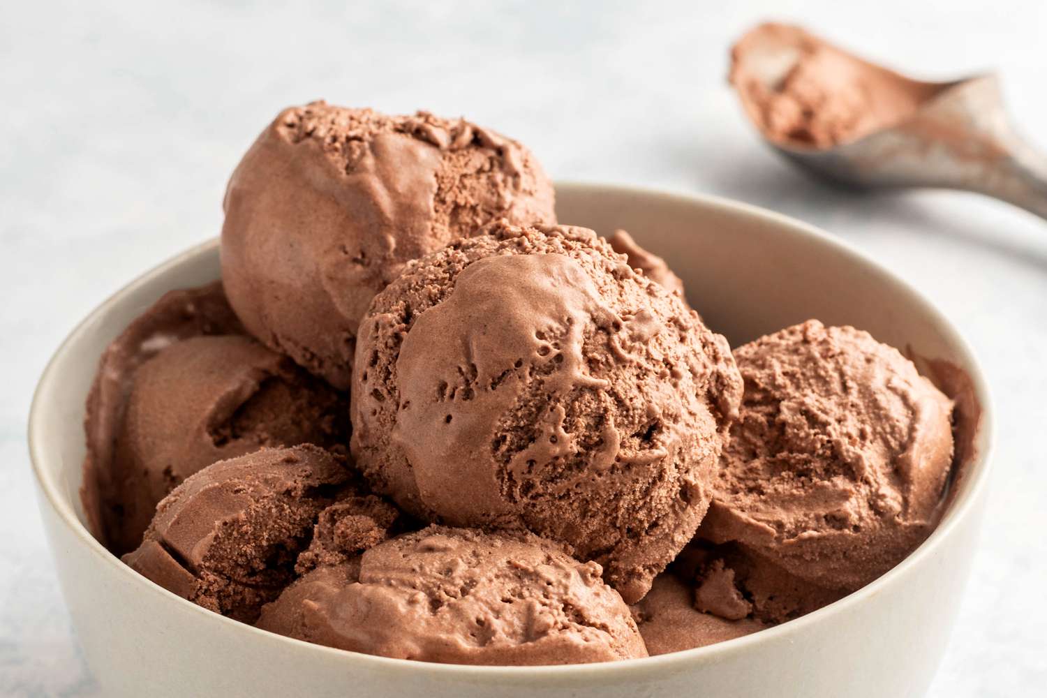 A scoop of rich chocolate ice cream melting slowly under a warm summer sun, showcasing its creamy texture and deep cocoa color, epitomizing indulgent satisfaction.