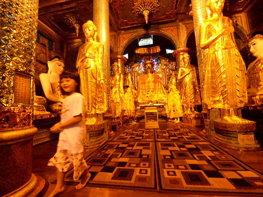 Devotees and monks performing rituals at the Shwedagon Pagoda, highlighting the spiritual atmosphere of the site 
