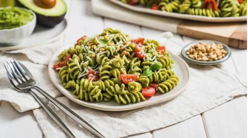 Semangkuk pasta saus alpukat creamy dengan irisan tomat ceri segar dan taburan keju parmesan