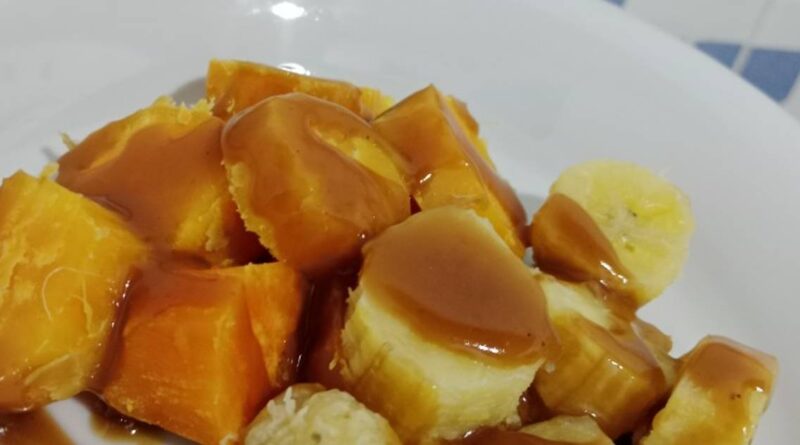 Pisang rebus gula yang manis dan harum, disajikan hangat dengan taburan kelapa parut untuk tambahan rasa gurih