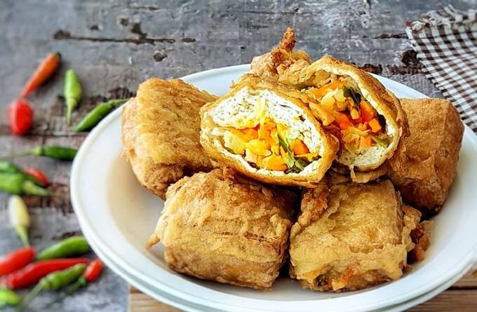 Tahu isi sayuran berwarna keemasan, tersusun rapi di piring putih