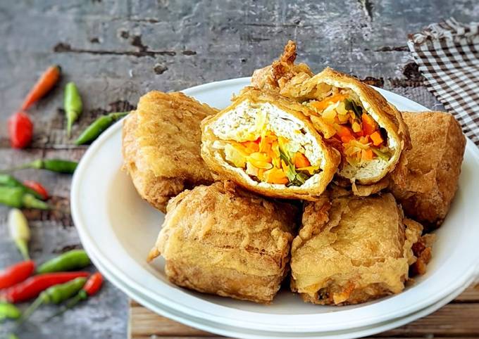 Tahu isi sayuran berwarna keemasan, tersusun rapi di piring putih
